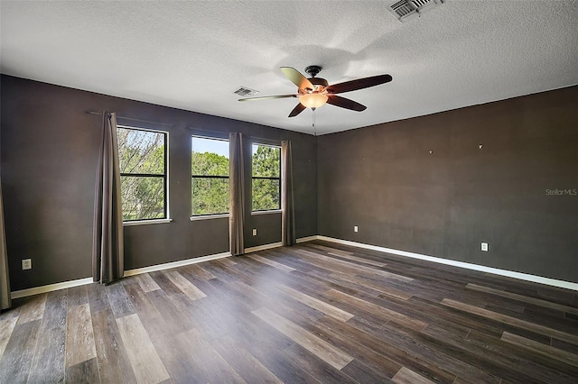 spare room featuring a textured ceiling, ceiling fan, and dark wood-type flooring