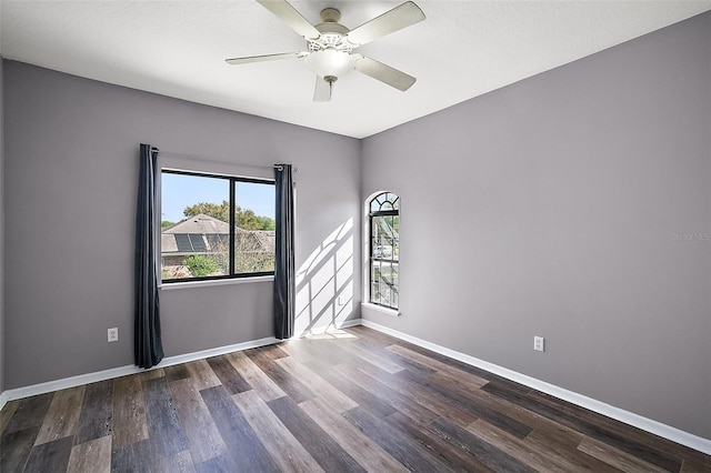 empty room with a wealth of natural light, ceiling fan, and dark hardwood / wood-style floors