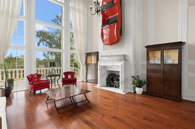 sitting room featuring plenty of natural light, a premium fireplace, and dark hardwood / wood-style floors