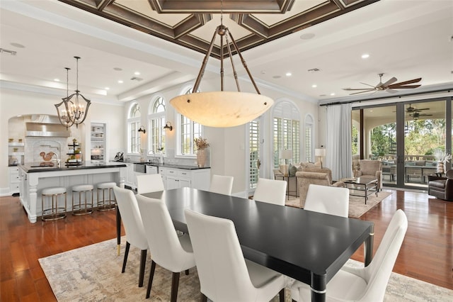 dining space with coffered ceiling, ceiling fan with notable chandelier, dark wood-type flooring, ornamental molding, and french doors