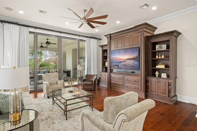 living room with ornamental molding, ceiling fan, and dark hardwood / wood-style floors