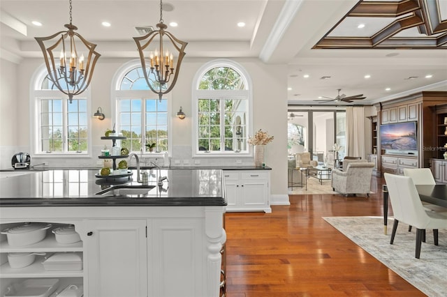 kitchen with coffered ceiling, sink, ceiling fan with notable chandelier, white cabinetry, and dark wood-type flooring