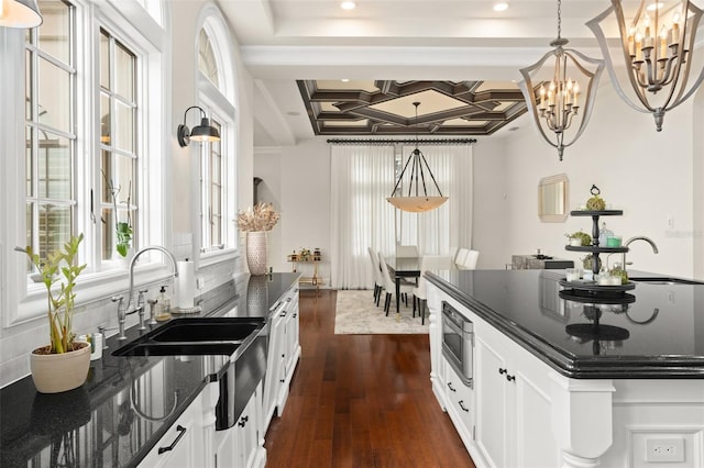 kitchen featuring coffered ceiling, white cabinets, decorative light fixtures, dark hardwood / wood-style flooring, and a chandelier