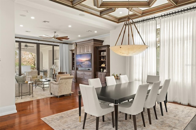 dining space with ornamental molding, ceiling fan, dark hardwood / wood-style floors, and coffered ceiling