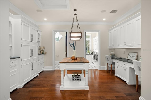 kitchen with independent washer and dryer, white cabinets, decorative light fixtures, and dark hardwood / wood-style floors