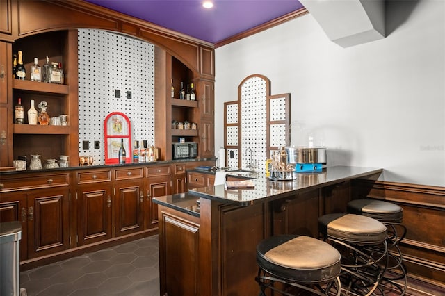 bar featuring dark stone counters and dark tile flooring