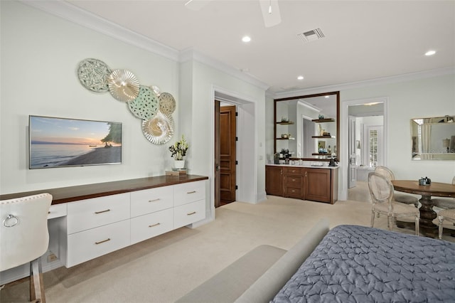 bedroom featuring crown molding, light colored carpet, built in desk, and ceiling fan