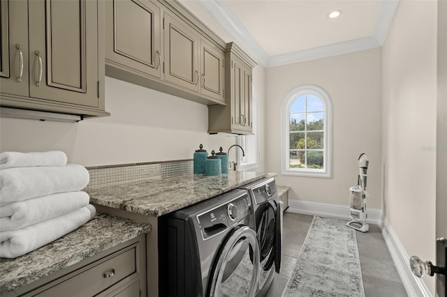 washroom featuring crown molding, light tile flooring, cabinets, and separate washer and dryer