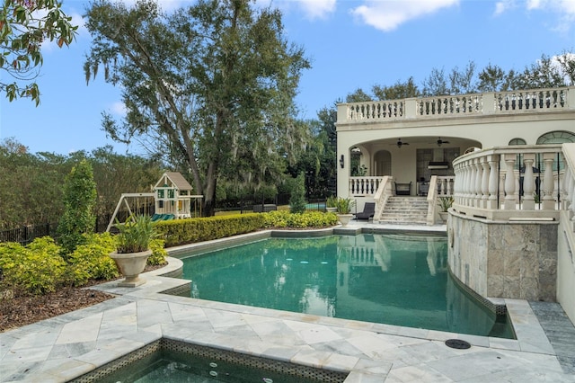 view of pool with a patio, a hot tub, ceiling fan, and a playground