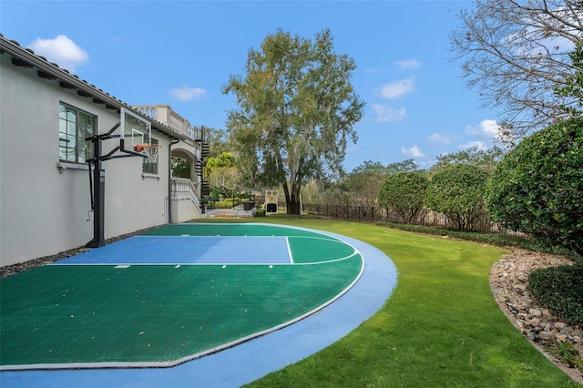 view of sport court with a lawn