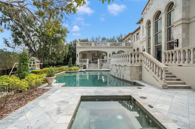 view of swimming pool with a patio and an in ground hot tub