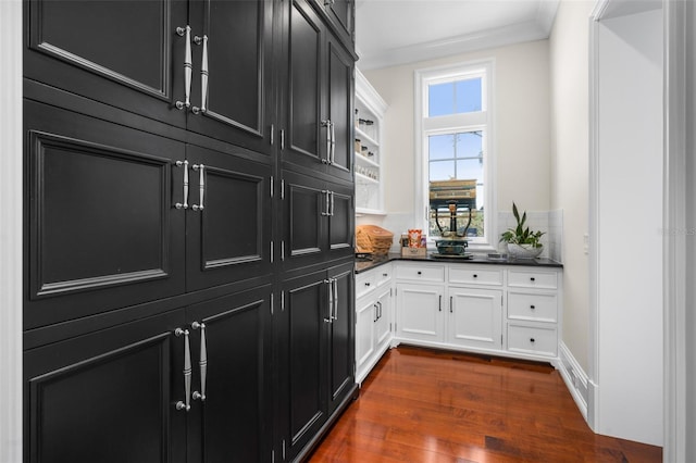 kitchen featuring dark hardwood / wood-style floors, white cabinetry, and ornamental molding