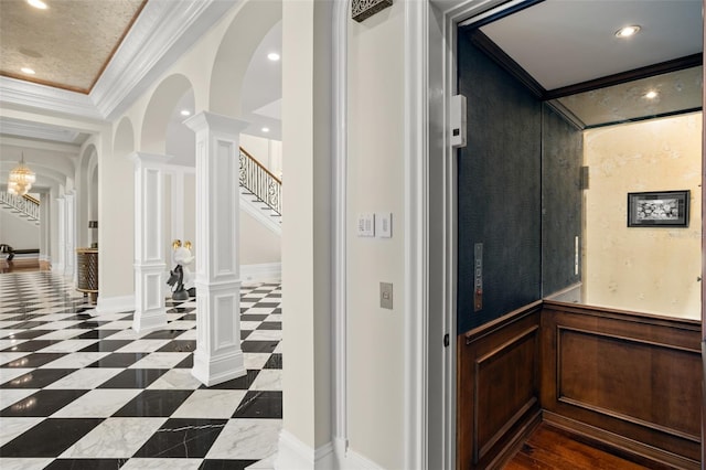 hallway with dark tile flooring, a tray ceiling, decorative columns, crown molding, and elevator