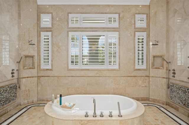 bathroom with tile walls, tiled tub, and tile flooring