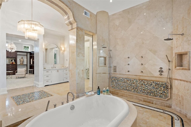 bathroom with tile flooring, a notable chandelier, vanity, and a bathing tub