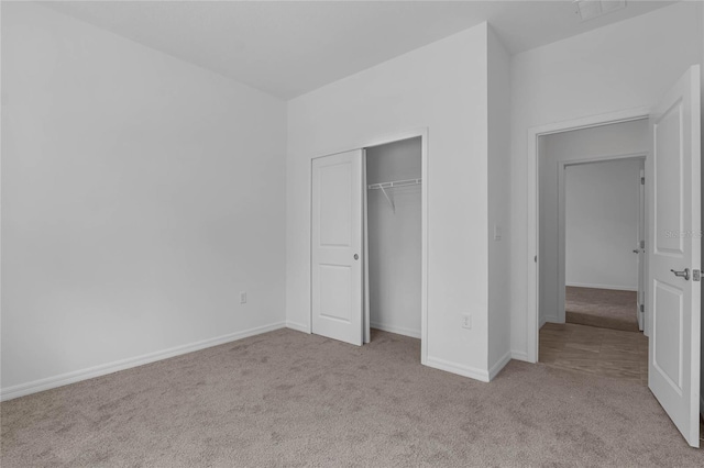 unfurnished bedroom featuring a closet and light carpet