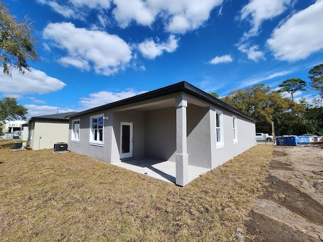 back of property featuring a patio area and a lawn