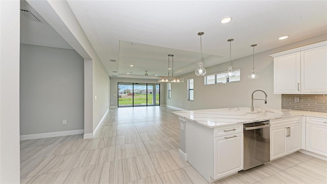 kitchen with light stone counters, dishwasher, sink, and white cabinets