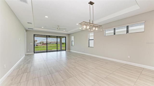 spare room featuring ceiling fan and a raised ceiling