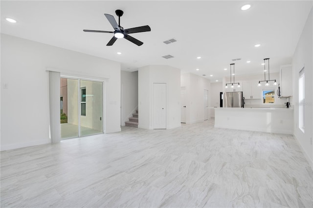 unfurnished living room with plenty of natural light and ceiling fan