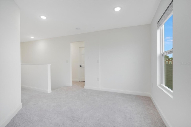 unfurnished room featuring plenty of natural light and light colored carpet