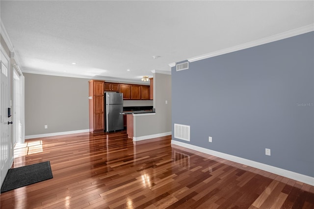 unfurnished living room featuring dark hardwood / wood-style floors and crown molding