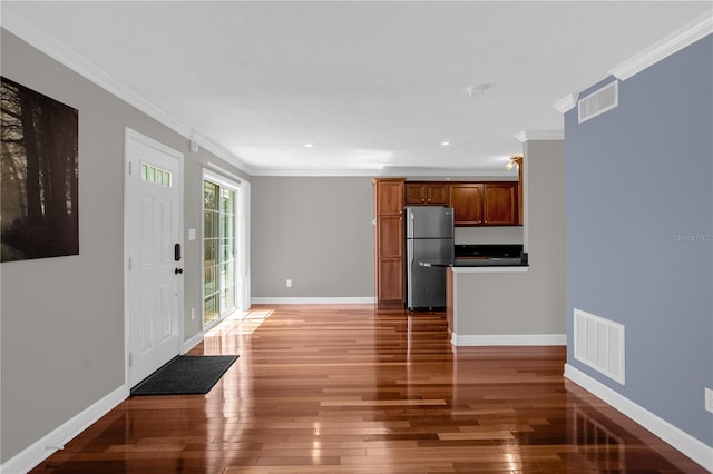 foyer entrance with dark hardwood / wood-style flooring and ornamental molding