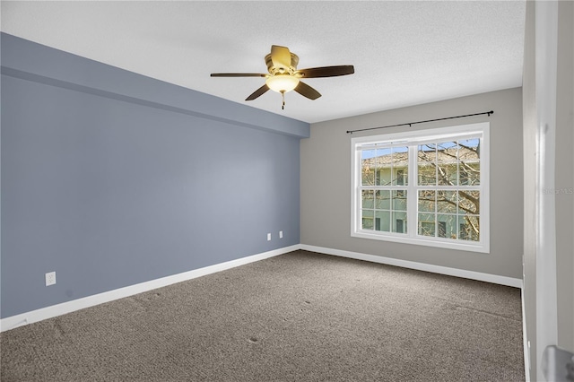 spare room with a textured ceiling, ceiling fan, and dark colored carpet