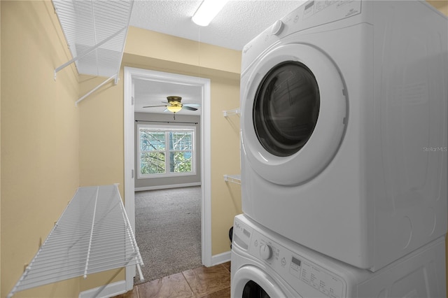 washroom featuring light tile flooring, a textured ceiling, stacked washing maching and dryer, and ceiling fan