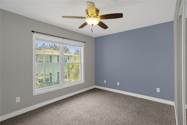 spare room featuring dark carpet and ceiling fan