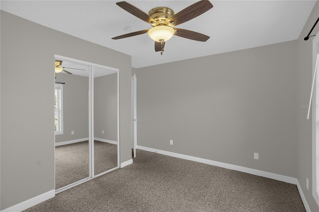 unfurnished bedroom featuring dark carpet, a closet, and ceiling fan