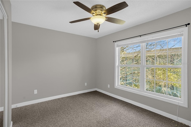 empty room with dark carpet and ceiling fan