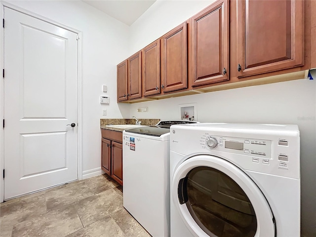 laundry room with cabinets, washing machine and clothes dryer, and sink