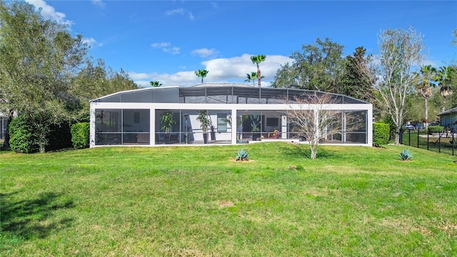 back of house featuring glass enclosure, fence, and a yard