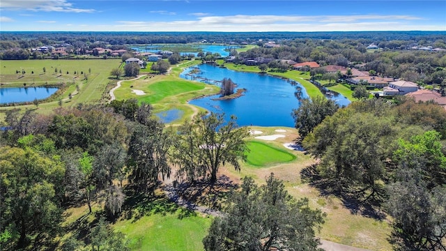 aerial view with view of golf course, a water view, and a view of trees