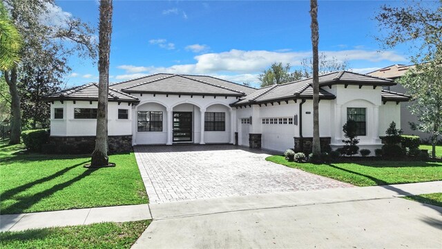 mediterranean / spanish home with a front yard and a garage