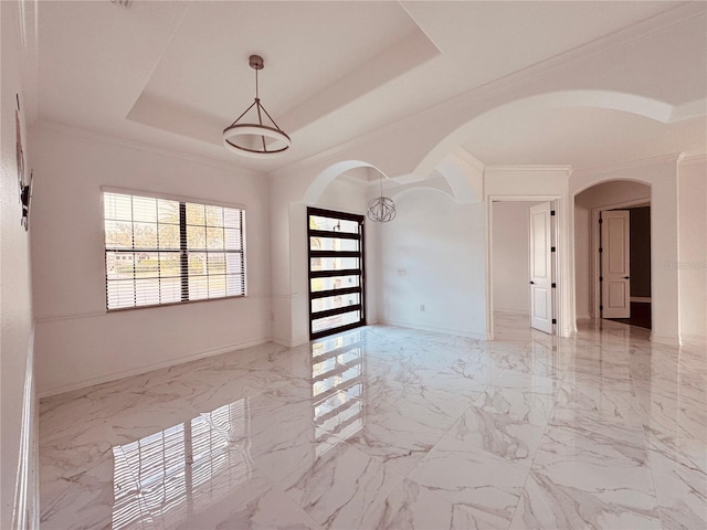 unfurnished room with crown molding and a raised ceiling