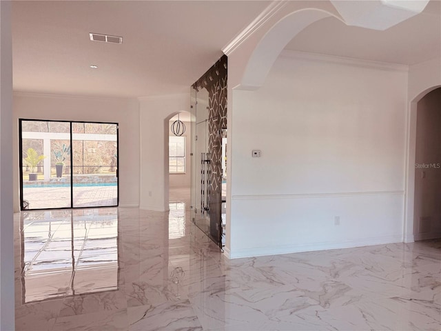 unfurnished room featuring arched walkways, marble finish floor, crown molding, visible vents, and baseboards