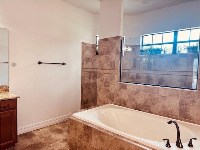 bathroom featuring vanity and a relaxing tiled tub