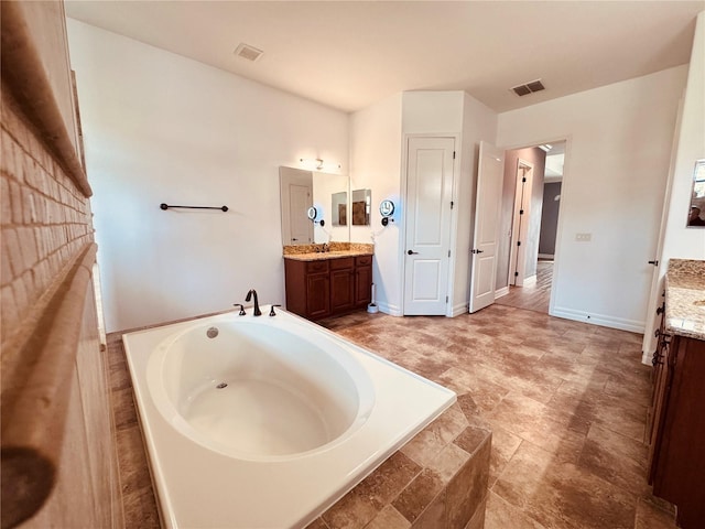 full bathroom featuring baseboards, visible vents, a bath, and vanity