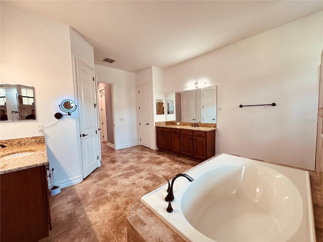 bathroom with vanity and a relaxing tiled tub