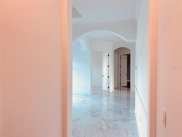 corridor featuring ornamental molding, arched walkways, marble finish floor, and baseboards