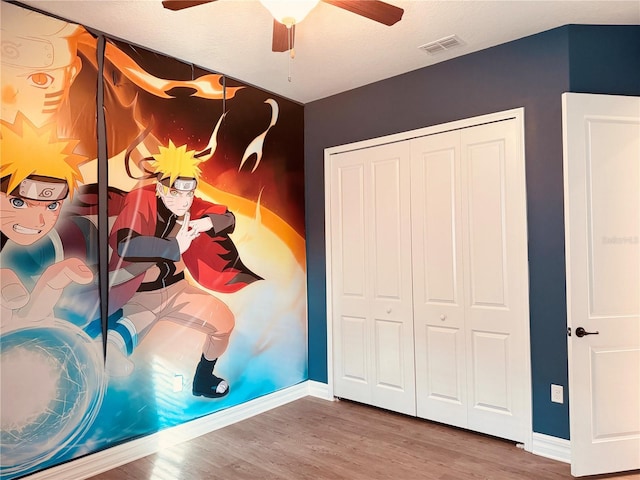 bedroom with ceiling fan, a closet, and wood-type flooring