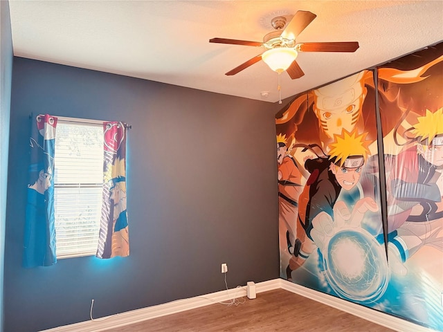 unfurnished room featuring a ceiling fan, a textured ceiling, baseboards, and wood finished floors