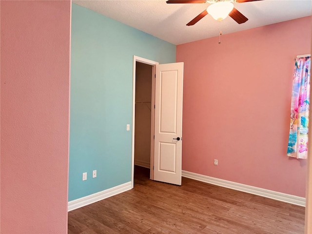 empty room with ceiling fan and hardwood / wood-style flooring