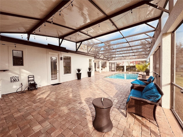 view of pool with glass enclosure and a patio