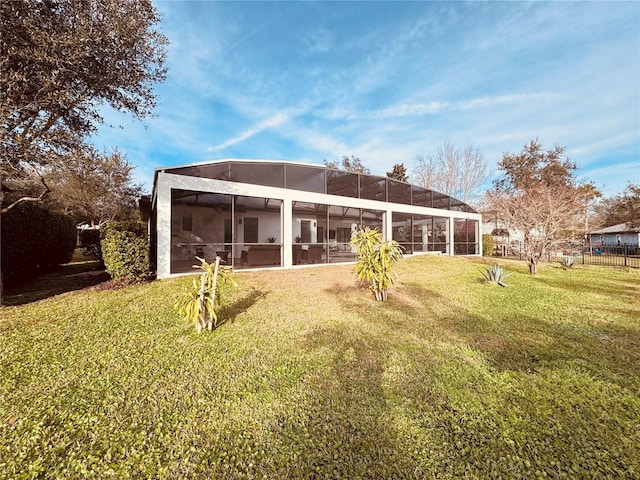 back of house with a lanai and a yard