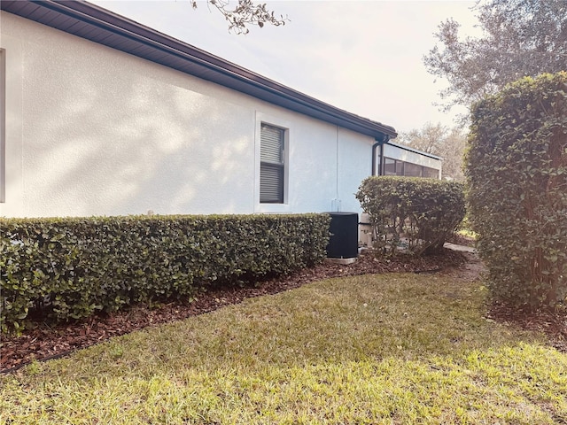 view of home's exterior with a yard, cooling unit, and stucco siding