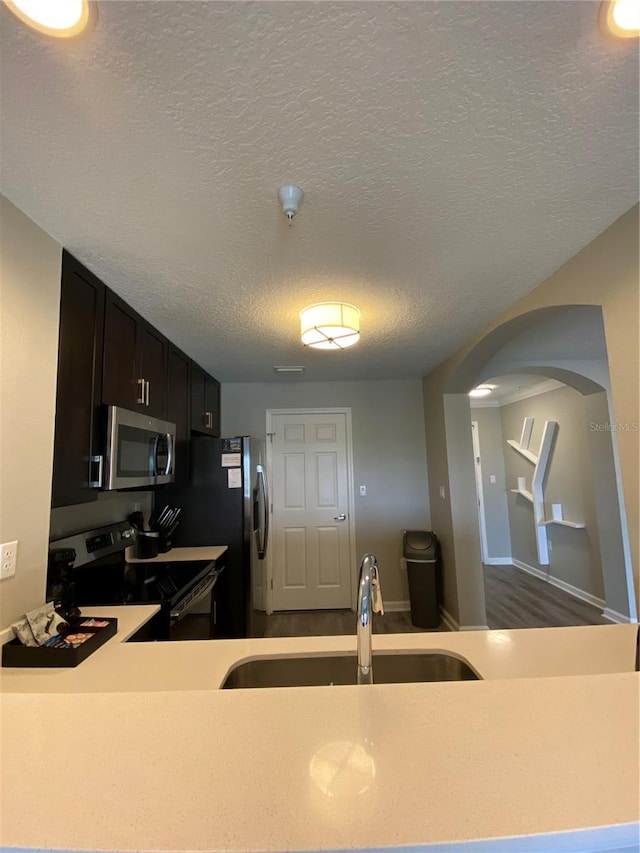 kitchen featuring a textured ceiling, sink, and electric range