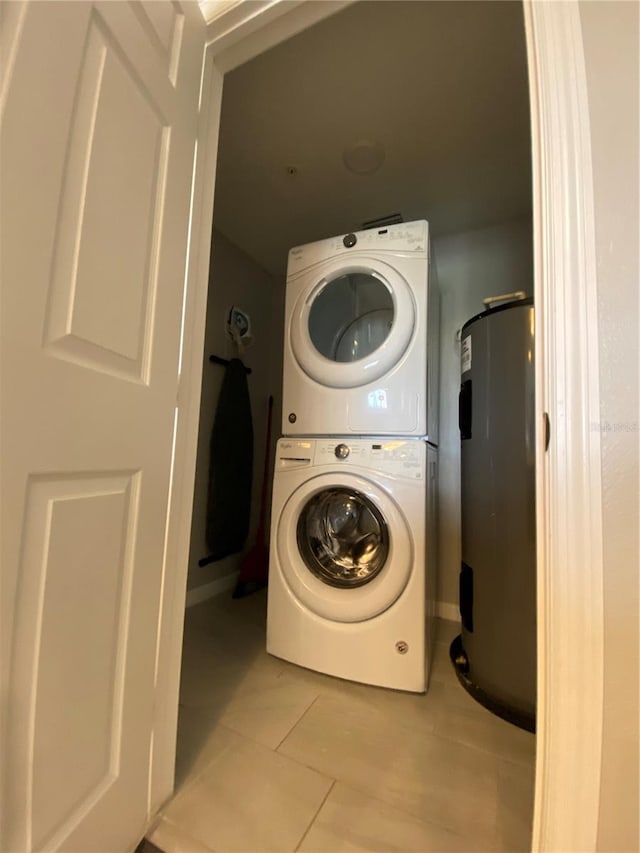 washroom with stacked washer and clothes dryer, light tile flooring, and water heater